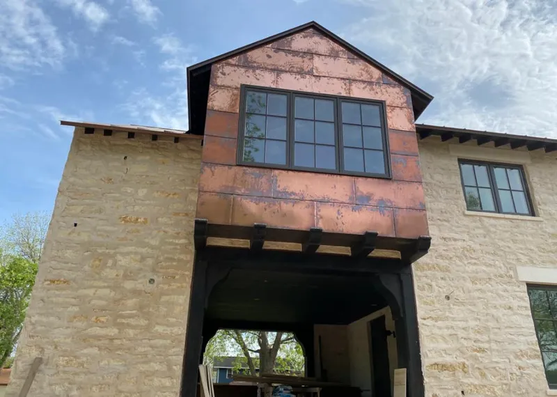 Copper metal panel facade on a stone building for Roof Repair in Gunbarrel